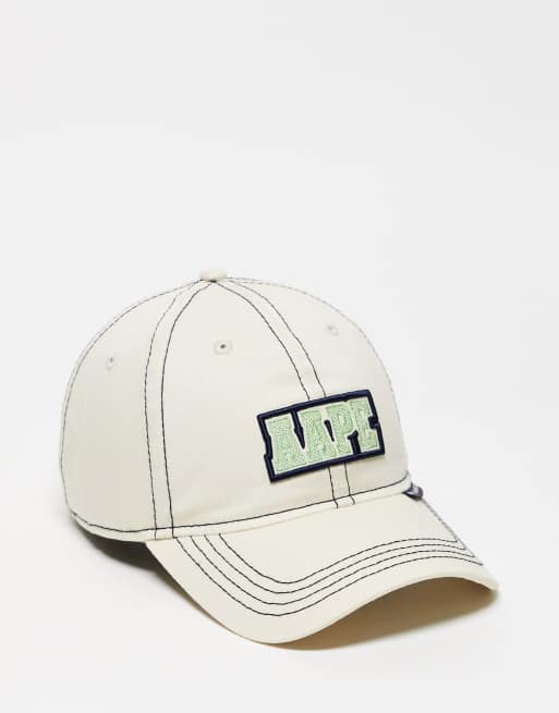 Gorra color crema con logo de AAPE