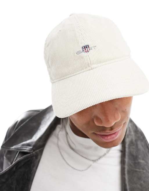 Gorra color crema con logo de escudo de pana de GANT