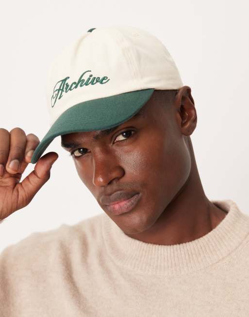 Gorra color crudo con visera y bordado verdes en contraste de ASOS DESIGN