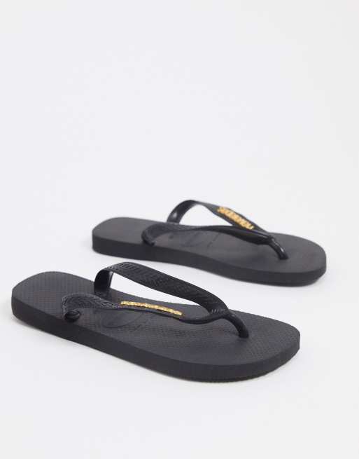 Havaianas metallic logo flip flops in black ASOS