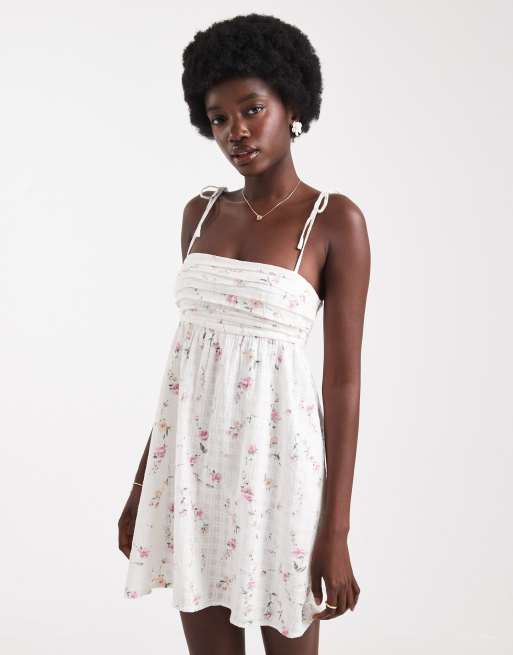 Hollister - Babydoll jurk met bloemenprint en strikbandje in wit