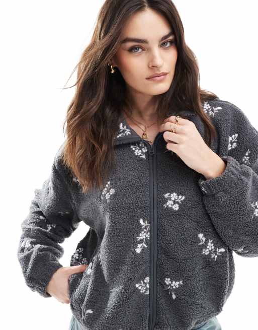 Hollister – Bestickte Fleece-Jacke in Schwarz mit Blumenmuster und Teddyfellfutter