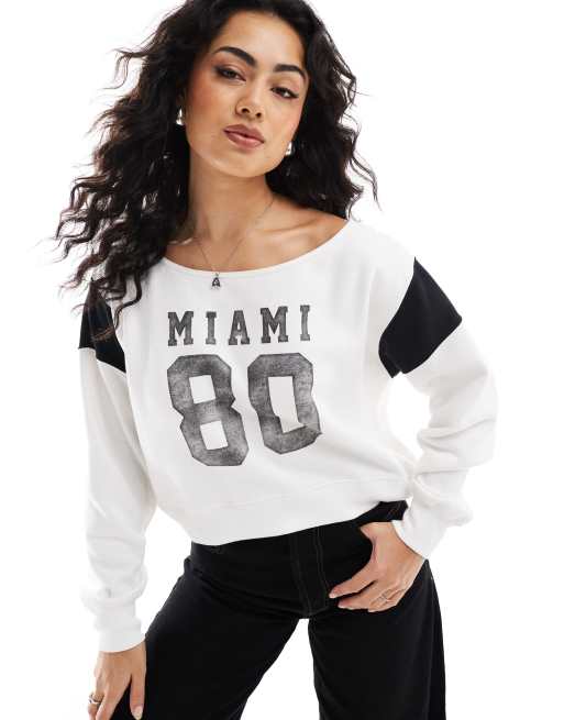 Hollister – Biały krótki sweter z odsłoniętymi ramionami i nadrukiem „Miami”