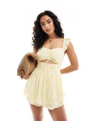 Hollister - Gepunkteter Playsuit in Zitronengelb mit Flatterärmeln und Cut-out-Design
