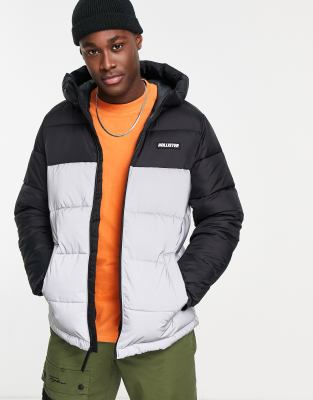 Hollister – Pufferjacke mit Kapuze, reflektierendem Logo und Farbblockdesign in Schwarz