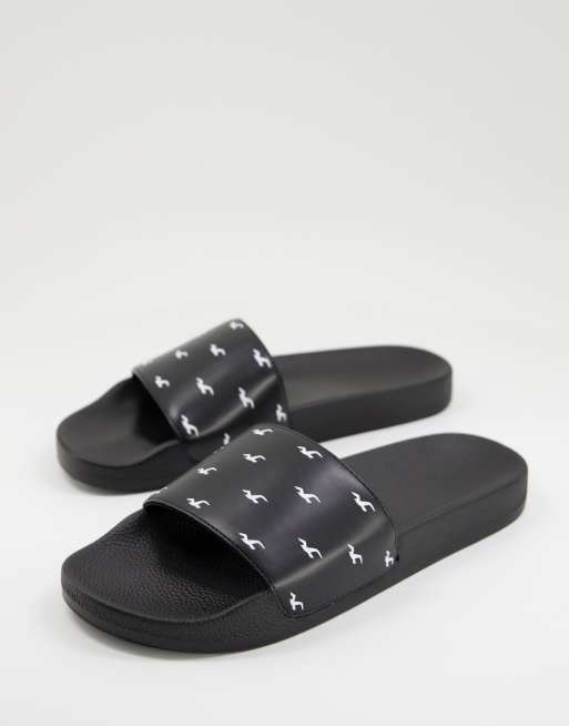 Hollister sliders with all over logo in black ASOS