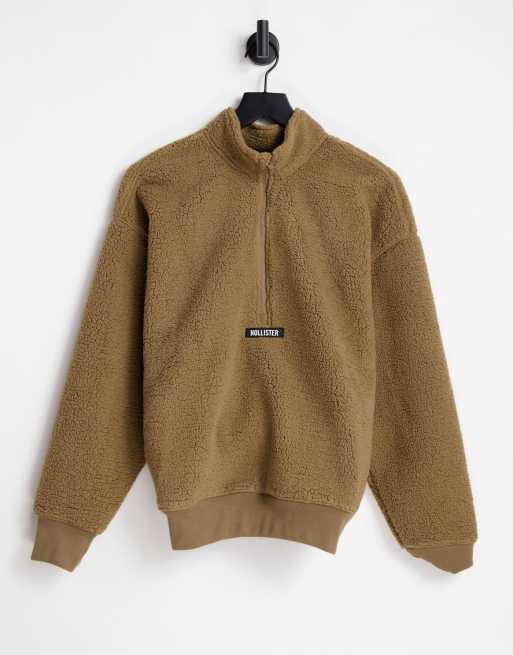Hollister - Trui van poolfleece met korte rits en logo op de borst in bruin