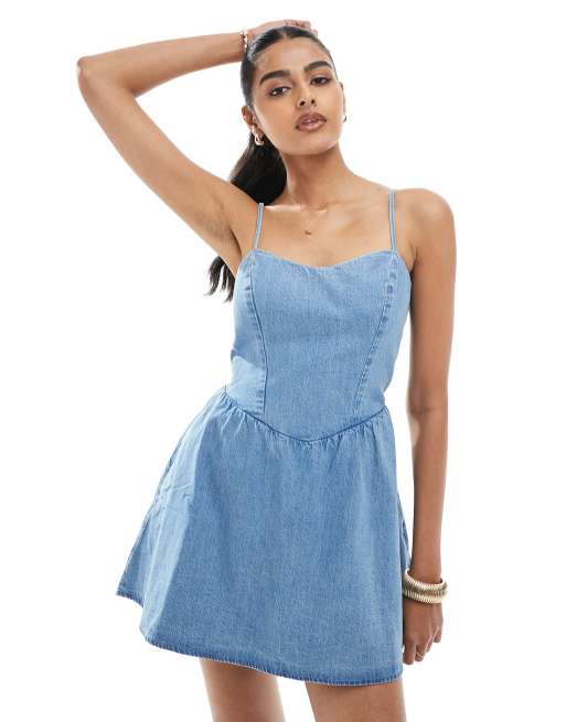 Hollister - Vestito corto senza maniche con vita scesa e allacciatura sul retro in denim lavaggio chiaro