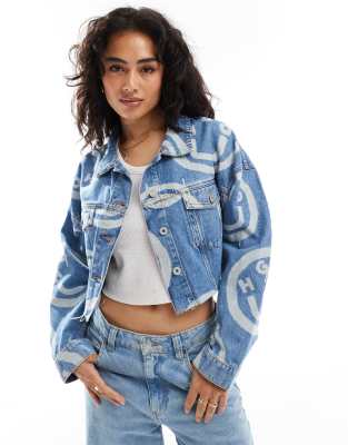 HUGO Blue - Lou - Kurze Jeansjacke in mittelblauer Waschung mit durchgehendem Logo-Muster