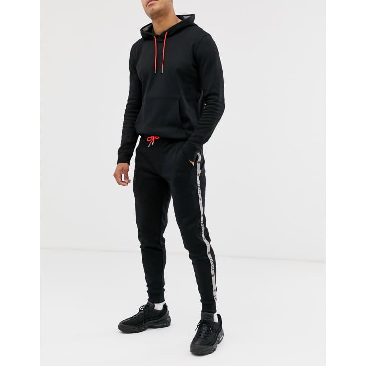 HUGO x Liam Payne side tape trackies in black | ASOS