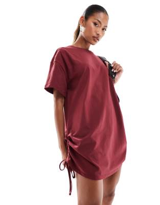 In The Style - Exklusives, kurzes T-Shirt-Kleid in Burgunderrot mit Oversize-Schnitt und geraffter Seite