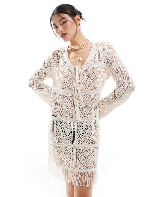 In The Style - Robe de plage courte en maille crochetée à ourlet frangé avec col en V à détail noué - Beige