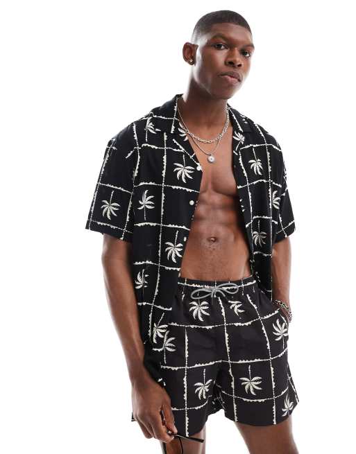 Jack & Jones - Camicia con collo a rever a maniche corte nera con stampa a griglia con palme in coordinato 