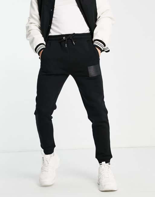 Jameson Carter leighton leather patch tapered joggers in black ASOS