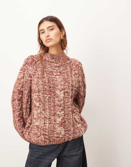 Jersey color crema y rojo con cuello alto y mangas voluminosas de punto de ochos de hilo retorcido de ARRANGE