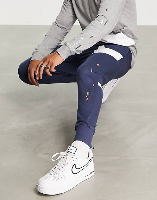 Hombre Joggers de ropa deportiva | Joggers azul trueno con bajos ajustados y logo de Nike - SD75016
