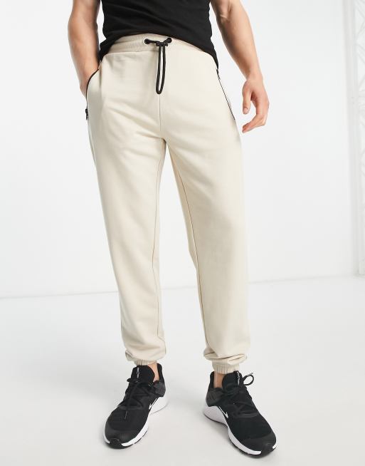 Joggers color arena pálido de corte slim con bolsillo de cremallera de Threadbare Fitness