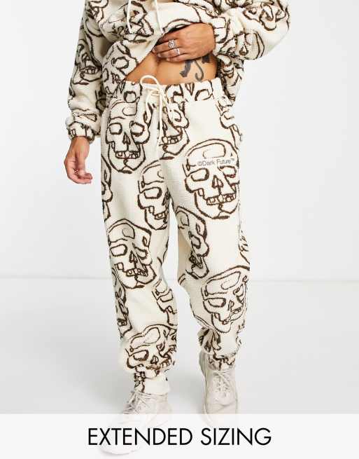 Joggers color crudo holgados con estampado integral de calaveras de borreguito de peluche de ASOS Dark Future (parte de un conjunto)