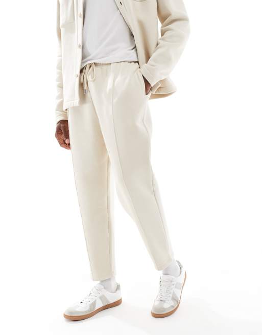 Joggers color piedra de corte tapered con bajo sobrehilado y detalle plisado de ASOS DESIGN