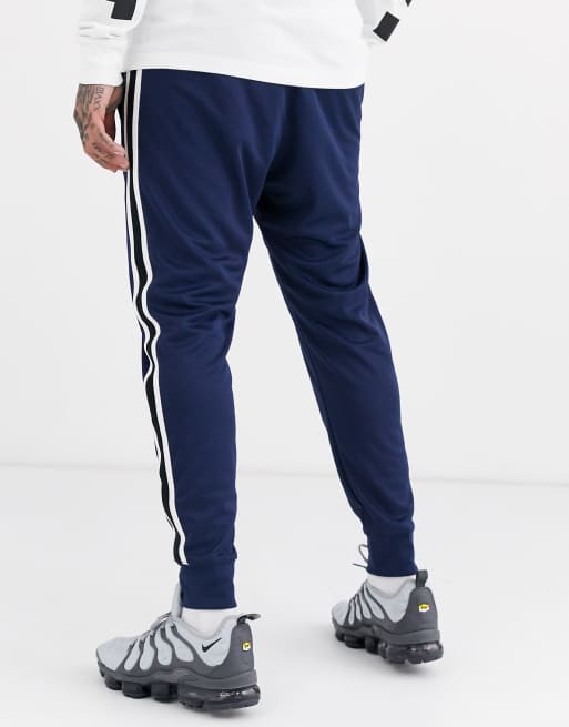 paz Miau miau Anillo duro Joggers con puños en azul marino Tribute de Nike | ASOS