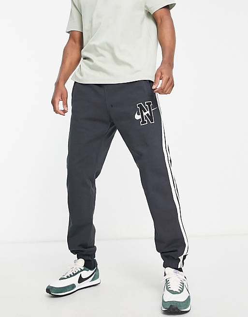 Hombre Joggers de ropa deportiva | Joggers de corte suelto con lavado negro y logo retro afelpado de Nike - MG76621