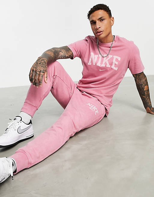 Hombre Joggers de ropa deportiva | Joggers holgados con lavado rosa y logo retro arqueado Retro Arch de Nike - UC69845