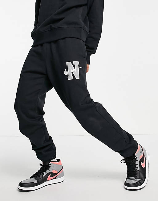 Hombre Pantalones y mallas | Joggers negros con bajos ajustados y logo de tejido grueso Retro de Nike - FT37626