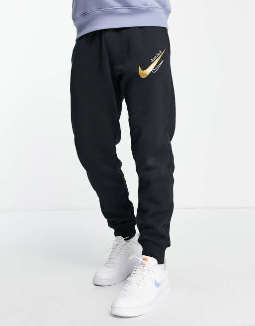 Joggers negros con logo dorado y bajos ajustados de Nike