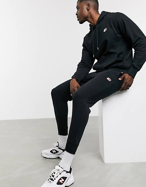 Hombre Joggers de ropa deportiva | Joggers negros con logo pequeño de New Balance - AZ96344
