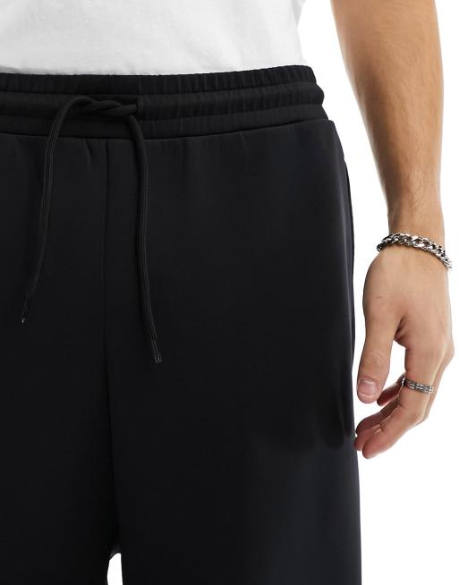 Joggers negros de corte ancho con bolsillos cargo de tejido efecto neopreno de ASOS DESIGN, 4 de 5