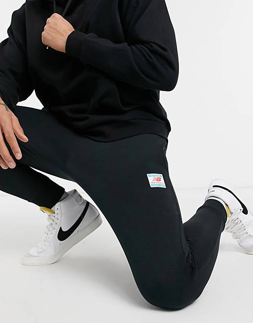 Hombre Pantalones y mallas | Joggers negros lavados con etiqueta con logo de New Balance - HG49847