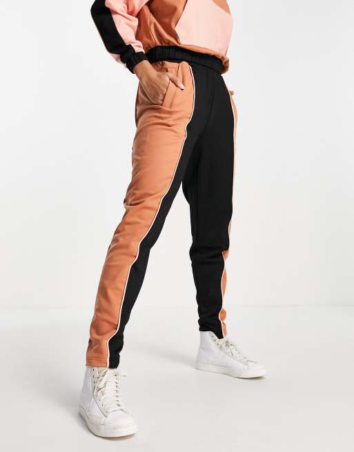 Joggers negros y naranjas con diseño color block de Fred Perry