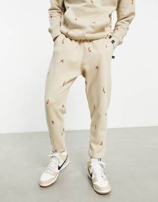 Jordan unisex essential joggers with all over logo in rattan - ASOS Price Checker