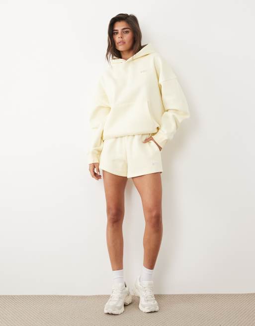 Kaiia - Coordinato con felpa con cappuccio oversize e pantaloncini della tuta in misto cotone color limone con logo in metallo argentato