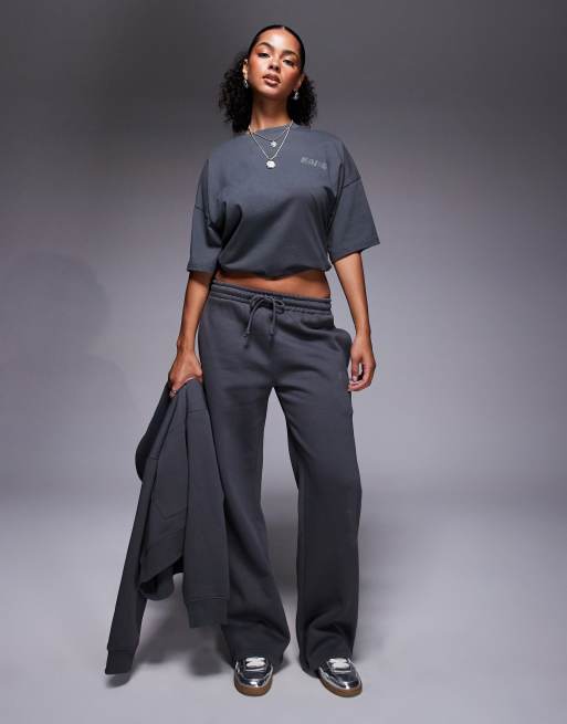 Kaiia - Joggers a fondo ampio color grigio scuro con decorazioni applicate a caldo in coordinato