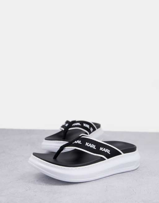 Karl Lagerfeld ‑ Kapri ‑ Zehenstegsandalen in Schwarz mit flacher Plateausohle und Logoriemen