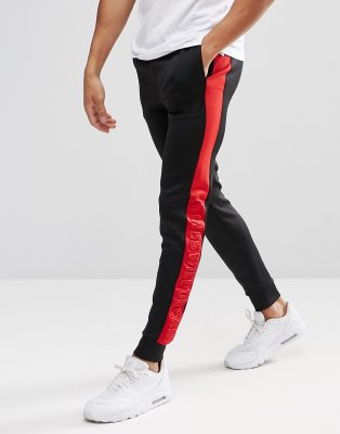 black tracksuit bottoms with red stripe