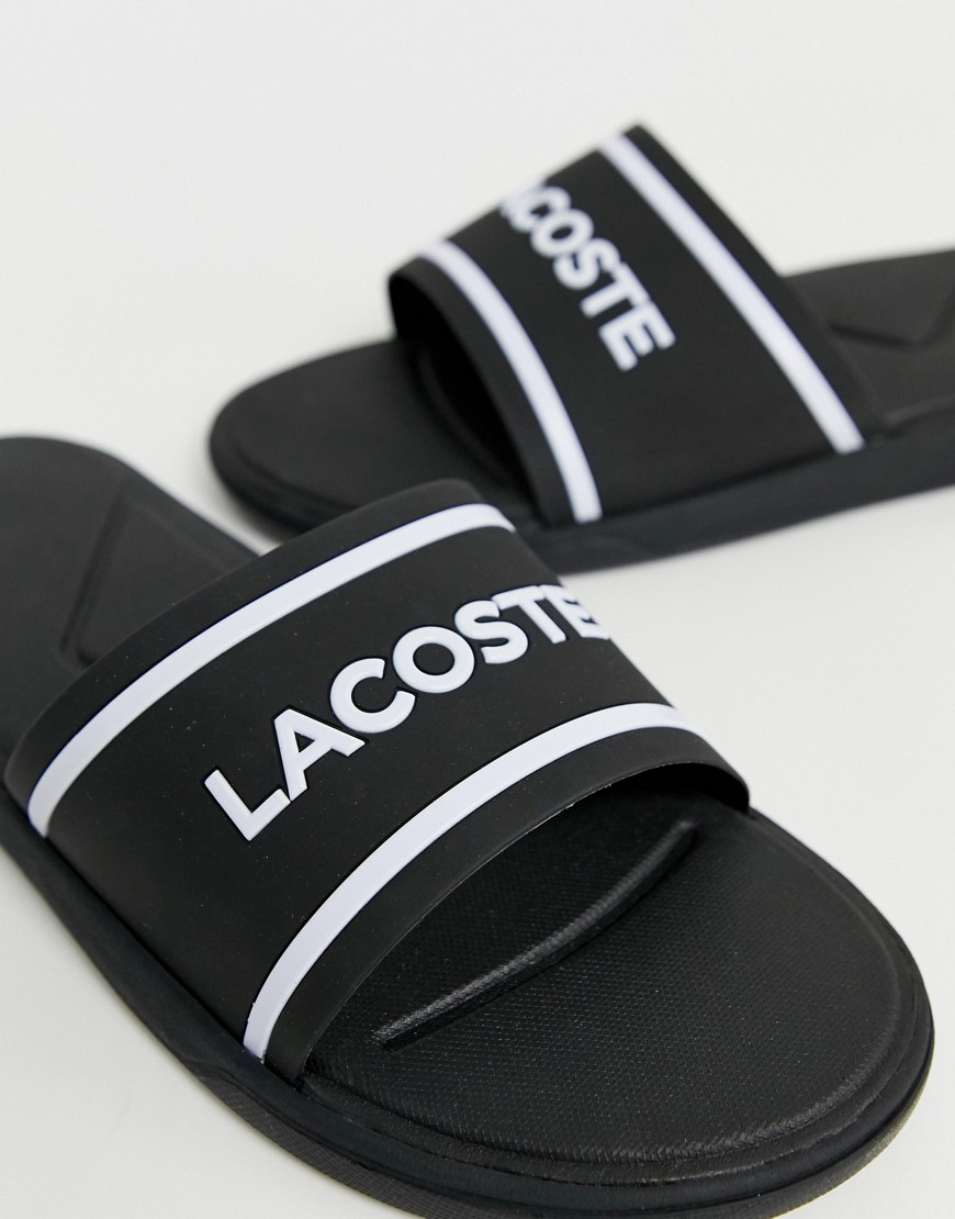 Lacoste – L30 – Svarta och vita tofflor med ränder