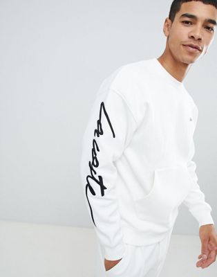 Lacoste – LIVE – Unisex-Sweatshirt am ASOS mit gebrochenem Weiß in | Ärmel Logoschriftzug