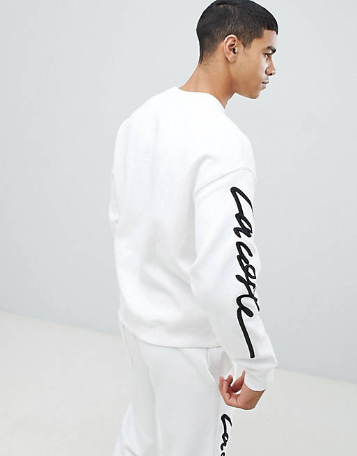 Lacoste – LIVE – Unisex-Sweatshirt in gebrochenem Weiß mit Logoschriftzug  am Ärmel | ASOS