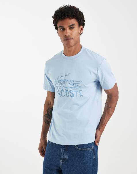 Lacoste – Niebieski T-shirt z grafiką z piaskowym logo - view 1