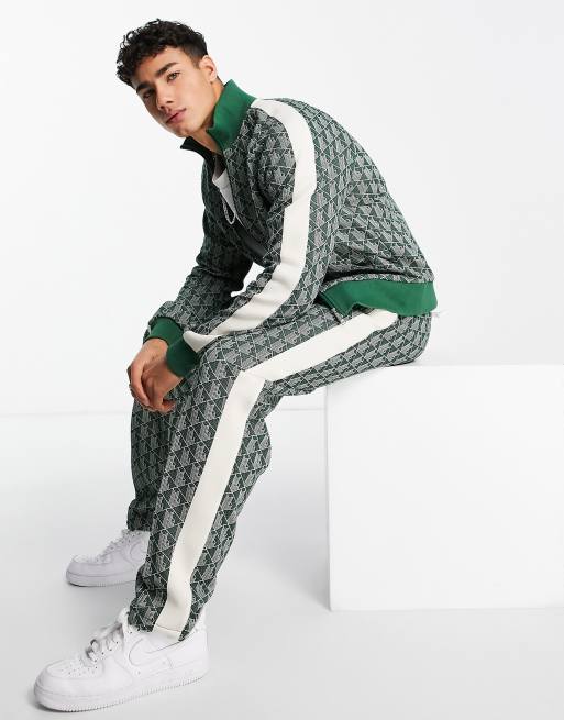 Lacoste – Zielone spodnie dresowe we wzór na całej powierzchni z lampasami