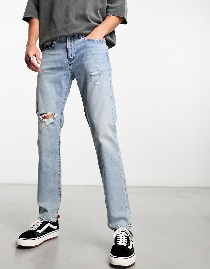 levi's 502 tapered fit jeans in light blue wash with rips