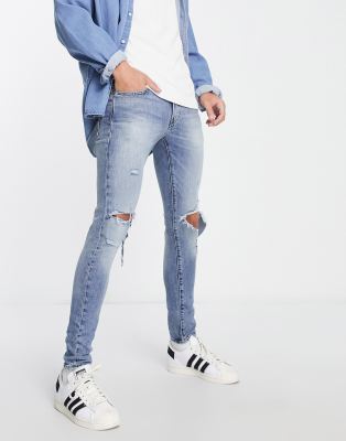 Levi's skinny taper fit jeans with rips in light wash blue - ASOS Price Checker