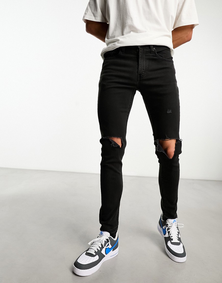 Levi’s Skinny tapered fit jeans in black with knee rips