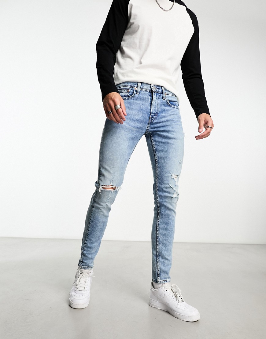 Levi’s Skinny tapered fit jeans in light blue wash with distressing