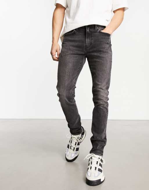 Levi's - Skinny, toelopende jeans met slijtageplekken in zwart
