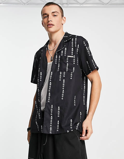 Liquor N Poker revere collared short sleeve shirt in black with all over japanese text print