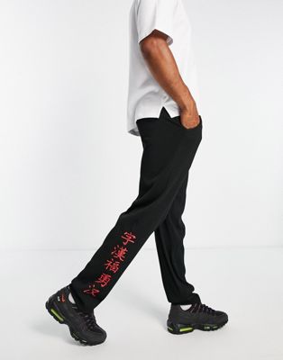 Liquor N Poker straight leg plisse trousers in black with japanese text print