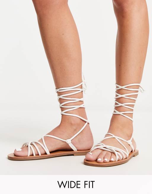 London Rebel Wide Fit – Flache Riemchensandalen in Weiß mit Beinschnürung und weiter Passform
